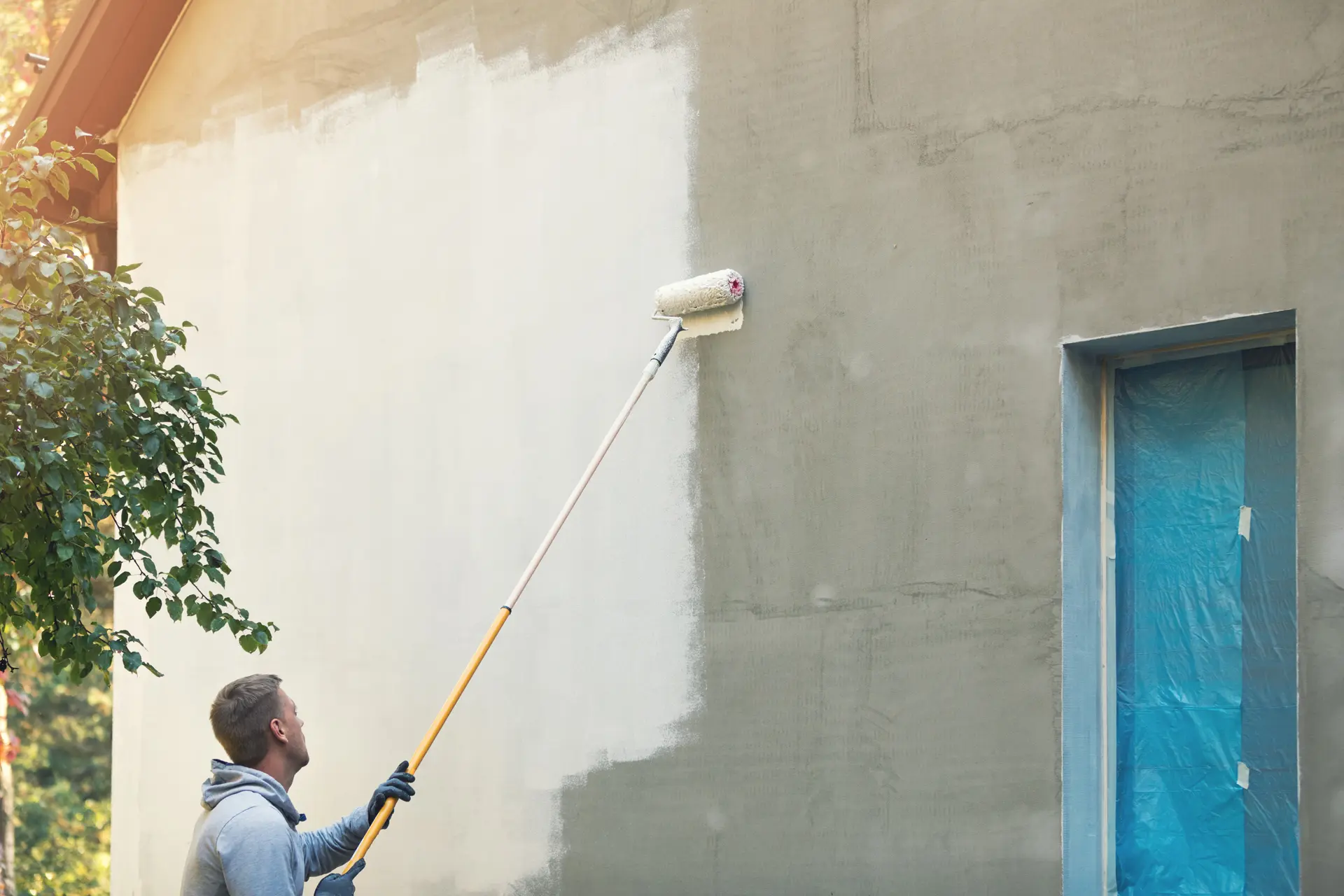 Pintor trabajando en una fachada en Santa Coloma